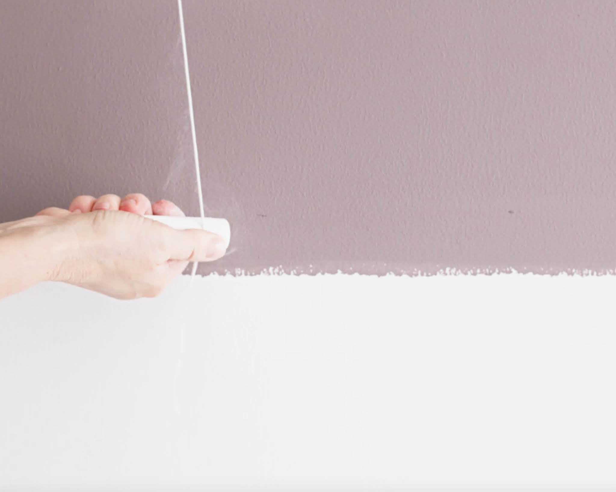 Đánh dấu đường ranh giới trên tường bằng phấn và sợi dây Đánh dấu đường phân cách giữa hai tông màu bằng phấn và sợi dây